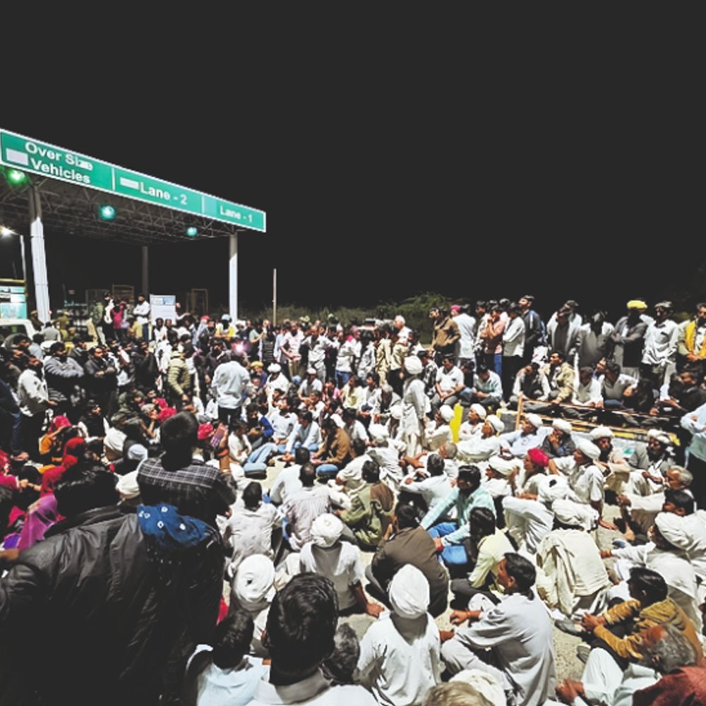 निंबाणियों की ढाणी टोल प्लाजा पर ही बैठे किसान:हाइटेंशन लाइनों के मुआवजे को लेकर ट्रैक्टर से बाड़मेर जा रहे किसानों को रोका, पुलिस से झड़प