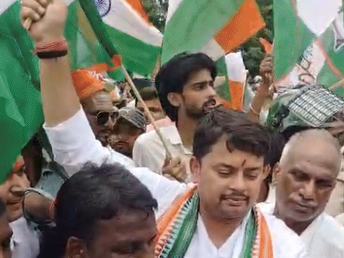 हाथों में तिरंगा लेकर रेलवे ट्रैक पर बैठे कांग्रेस कार्यकर्ता:बक्सर में रेलवे क्रासिंग बंद होने के विरोध में चक्का जाम, कई ट्रेनें लेटे