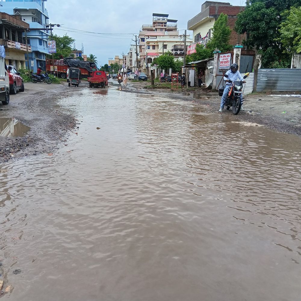 बेतिया में बारिश से सड़क बनी तालाब:ओवरब्रिज निर्माण के कारण 2-3 साल से गड्ढे, पानी भरने से हादसे का खतरा; बाइक सवार गंभीर घायल