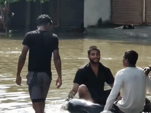 कानपुर में वाटरपार्क बनी सड़क VIDEO:पांडू नदी के पानी से रोड पर जलभराव, टायर-ट्यूब चला रहे बच्चे; जलभराव के बीच खेला अबीर-गुलाल
