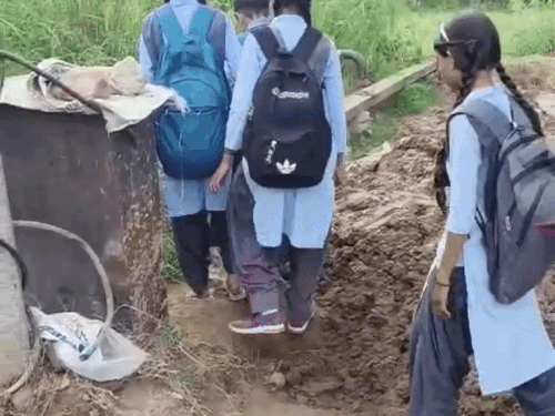 करंट के खतरे के बीच स्कूल जा रहे बच्चे:सीवर लाइन डालने से लीकेज, गांव की मुख्य सड़क पर कीचड़ का दलदल