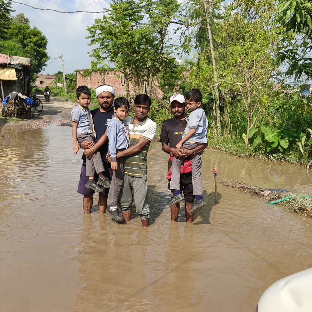 मधुबनी में 2 फीट पानी में डूबी सड़क:गोद में उठाकर बच्चों को पार कराते हैं युवक, गड्ढे में फंसकर पलटने से बचा ई-रिक्शा