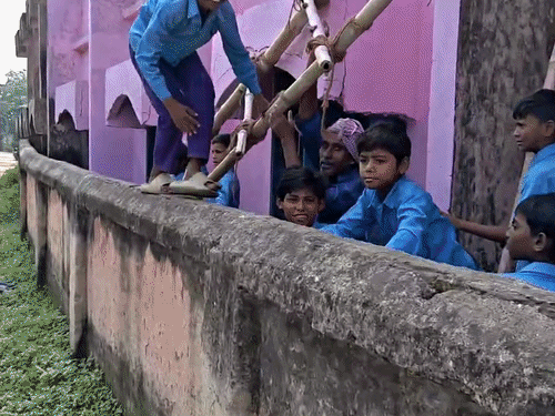 बच्चों को 8 फीट दीवार पर चढ़ाकर सीढ़ी उठवाई:जमुई स्कूल में चल रहा था रंगाई-पोताई का काम, जर्जर छज्जे के नीचे खड़े दिखे छात्र